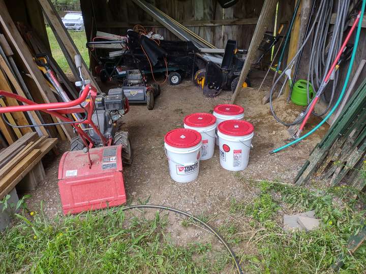 Harvesting buckets ready to collect (food grade, of course) on the ground in a large barn door with roto tiller to left